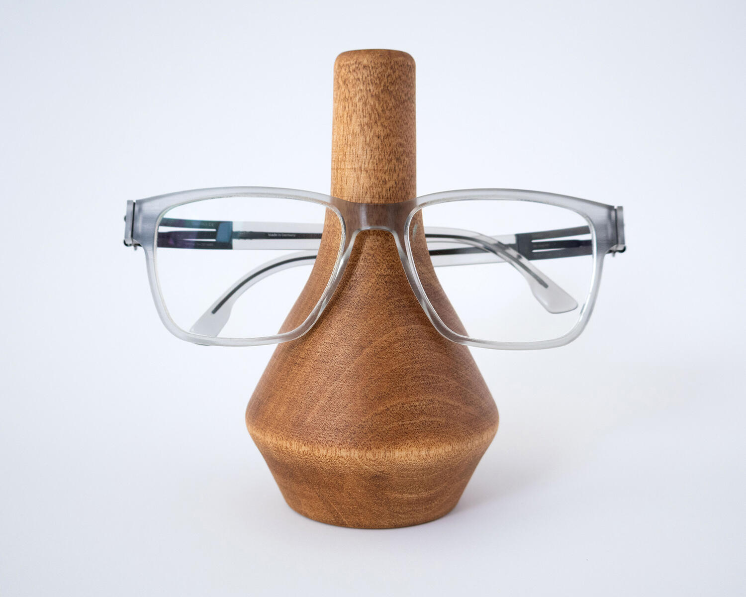 eyeglass holder made out of birch wood with eyeglasses on stand on white background