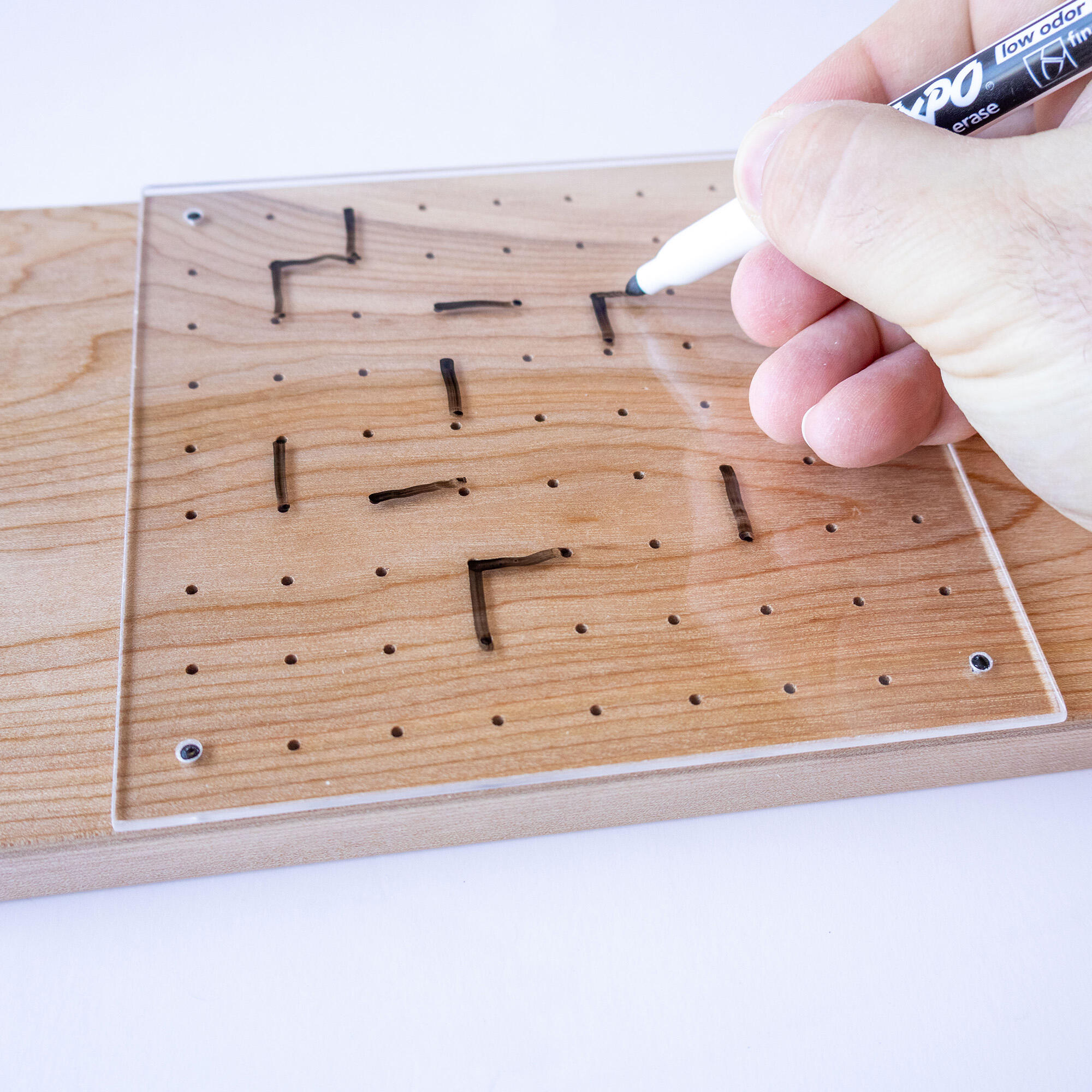 Close-up of a match in progress on a birch dots & boxes reusable board, showing the satisfying tactile experience of playing on a clear reusable surface.
