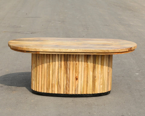 Solid mango wood oblong coffee table with repeating pattern ribbing base in natural finish.