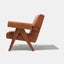Caramel brown leather lounge chair with leather armrests and solid ash wood legs stained walnut.