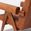 Caramel brown leather lounge chair with leather armrests and solid ash wood legs stained walnut. Armrest detail.