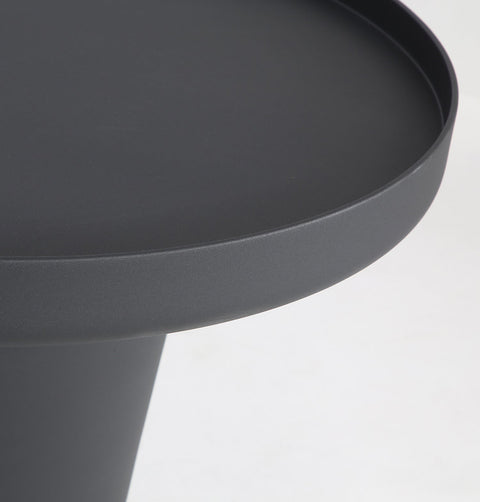 Minimal black powder coated aluminum side table resembling a pier bollard with a black marble base. Top detail.
