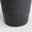 Minimal black powder coated aluminum side table resembling a pier bollard with a black marble base. Bottom detail.
