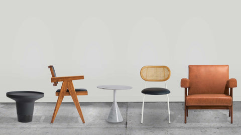 Pier side table, Nehru dining chair, Anja side table, Myla Boho dining chair & Nehru Lounge chair from left to right on concrete floor & white background.