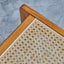 Lounge chair in walnut stained ash wood frame with natural rattan seat and back. Seat detail.