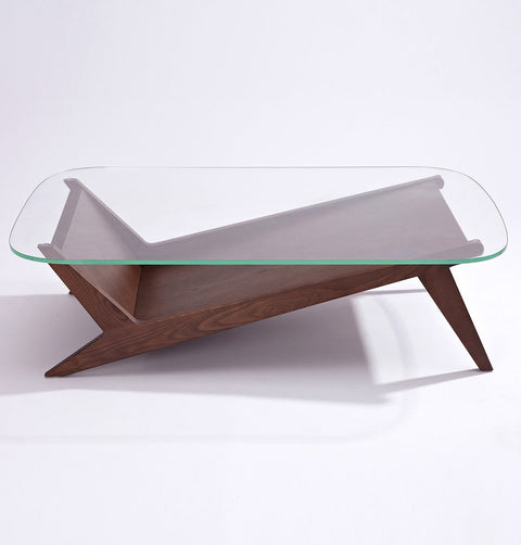 Coffee table with tempered glass top and walnut stained solid ash wood legs. Solid wood shelving in a check mark shape follows the leg contour.